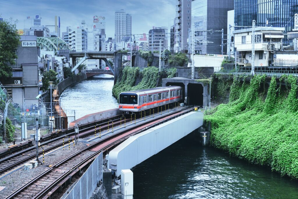 red and white train on rail near city buildings during daytime